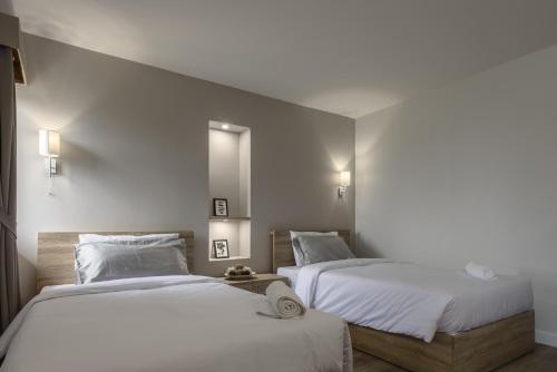 two beds sitting next to each other in a room at Carnation Residence in Samut Prakan