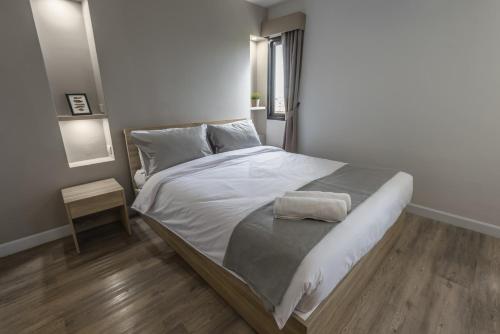 a bedroom with a large bed with white sheets at Carnation Residence in Samut Prakan