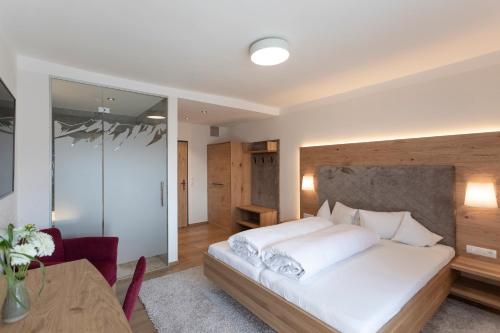 a bedroom with a large white bed and a table at Isserwirt in Innsbruck