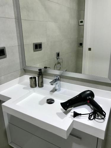 a white bathroom sink with a black phone on it at Sunset Drive Vistas Magicas in Benidorm