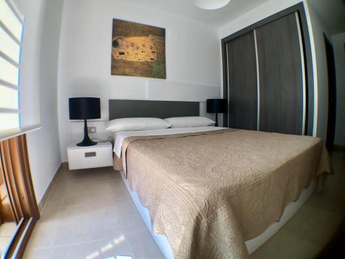 sypialnia z dużym łóżkiem i oknem w obiekcie Terrazas de Campoamor Barbara w mieście Playas de Orihuela