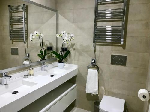 a bathroom with a sink and a mirror and a toilet at Sunset Drive Vistas Magicas in Benidorm