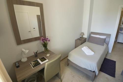 a bedroom with a bed and a desk with a mirror at B&B dei Ciclopi in Salice Salentino