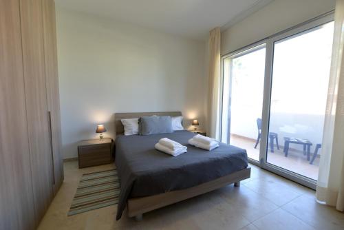 a bedroom with a bed and a large window at B&B dei Ciclopi in Salice Salentino