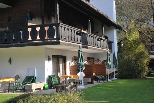 a house with a balcony and a table and chairs at Appartementhaus Florianshof in Garmisch-Partenkirchen