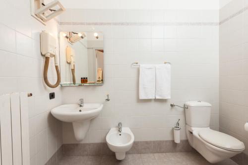 a white bathroom with a toilet and a sink at Hotel Villa Isabella in Brenzone sul Garda