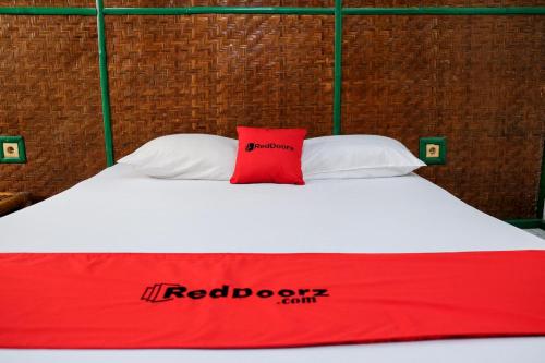 a red and white bed with a red and white pillow at RedDoorz Plus near Jalan Baru Bogor in Bogor