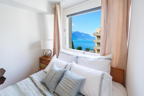 a bedroom with a bed with a large window at Central Apartment with Terrace in Montreux