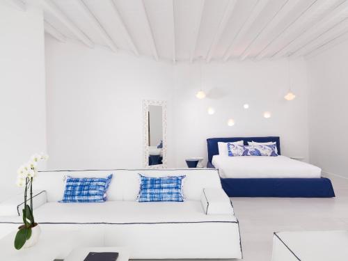 a white room with a couch and two beds at Katikies Mykonos - The Leading Hotels of the World in Agios Ioannis Mykonos