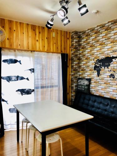a table and chairs in a room with a brick wall at Midtown Sakura Apartment House 202 予約者だけの空間 A space just for you in Nachikatsuura