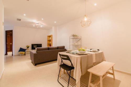 ein Wohnzimmer mit einem Tisch und einem Sofa in der Unterkunft Apartamento El Patio de Canovas in Cádiz