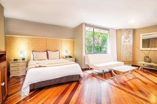 Un dormitorio con una cama grande y una ventana en Lloyds Apartasuites Parque 93, en Bogotá