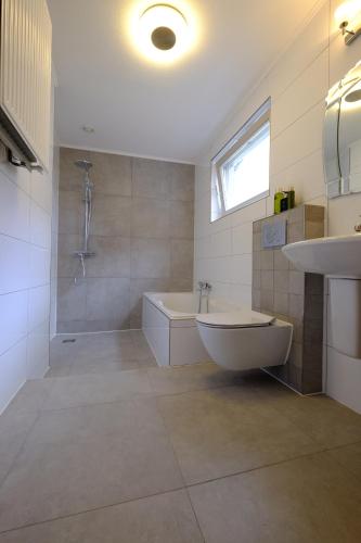 a bathroom with a tub and a shower and a sink at Citycenter Residence in Amsterdam