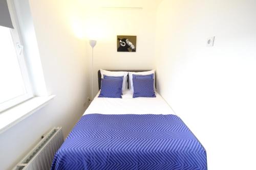 a small bedroom with a blue and white bed at Citycenter Residence in Amsterdam