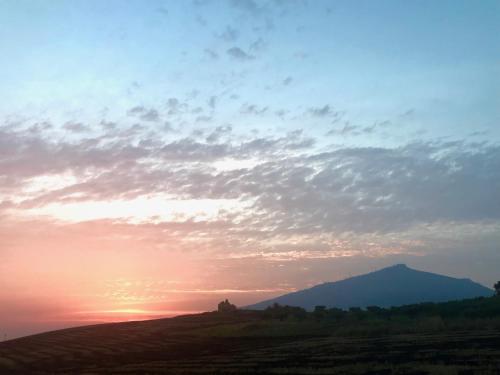 a sunset over a hill with a mountain in the background at MiraErice in Napola