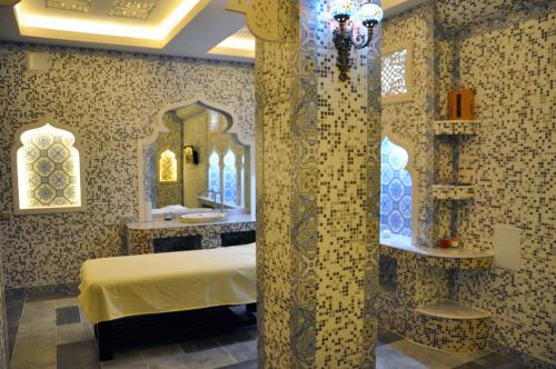 a room with a bed and a bathroom with a mirror at Parliament Palace Hotel in Khujand