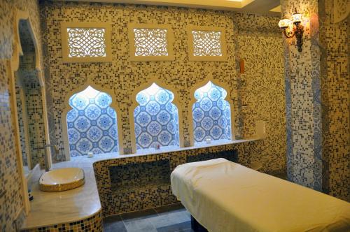 a bathroom with blue and white tiles and a tub at Parliament Palace Hotel in Khujand