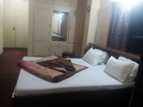 a bed with a brown blanket on top of it at Hotel Welcome in Rawalpindi