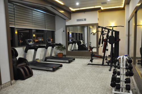 a gym with several treadmills and machines in a room at Parliament Palace Hotel in Khujand
