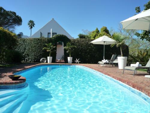 a swimming pool with a house in the background at Rothman Manor in Swellendam