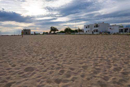 a person standing on a sandy beach at Andrew'S home - Playita in Torre Pali 