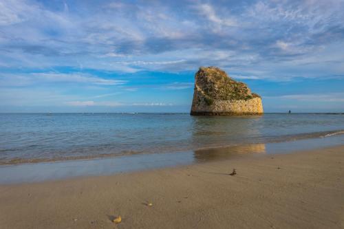 a large rock in the water on a beach at Andrew'S home - Playita in Torre Pali 