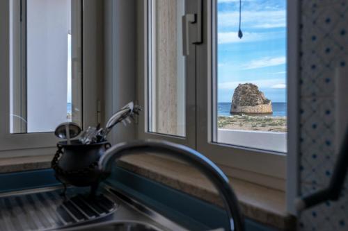 a sink and a window with a view of the ocean at Andrew'S home - Playita in Torre Pali 