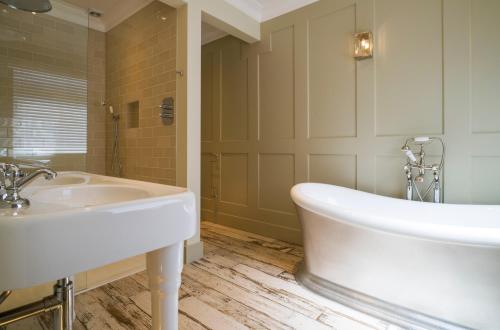 a bathroom with a white tub and a sink at Penventon Park Hotel in Redruth