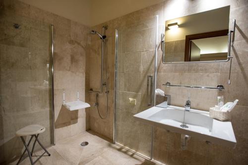 a bathroom with a shower, sink, and tub at Hotel Flora in Cagliari