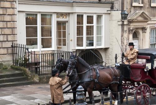 two men are standing next to a horse drawn carriage at The Paragon Townhouse in Bath