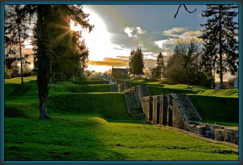 a set of stone steps in a park with the sun setting at Meublé de tourisme La Maison d'Orgy in Chevannes