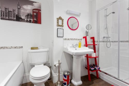 a bathroom with a toilet and a sink and a shower at Mama’s Inn Boutique Guest House in Nottingham