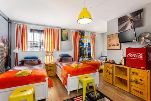 a bedroom with two beds and a television in it at Mama’s Inn Boutique Guest House in Nottingham