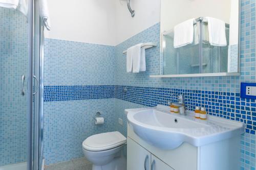 a blue tiled bathroom with a sink and a toilet at Andrew'S home - Playita in Torre Pali 