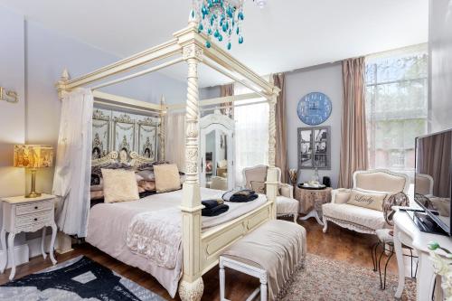 a bedroom with a white canopy bed and a desk at Mama’s Inn Boutique Guest House in Nottingham