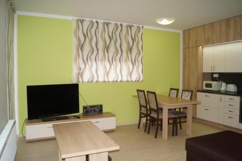 a living room with a table and a television at Apartments Klinovec in Loučná pod Klínovcem