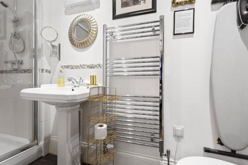 a white bathroom with a sink and a shower at Mama’s Inn Boutique Guest House in Nottingham