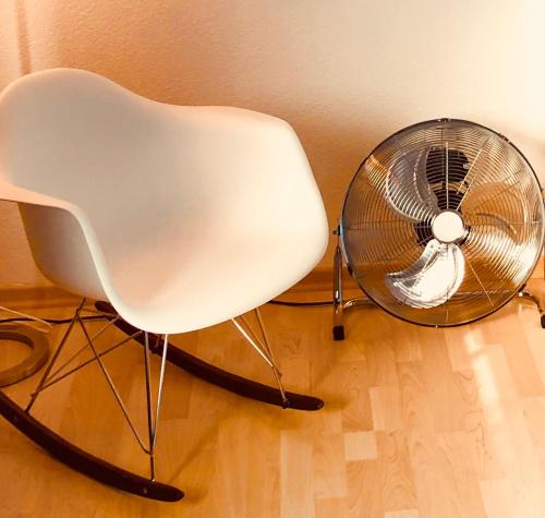a white chair and a fan in a room at smart&beautiful Guesthouse in Nordkirchen