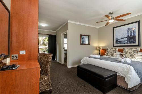 a bedroom with a bed and a ceiling fan at Abalone Guest House in Port Elizabeth