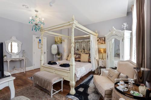 a bedroom with a white canopy bed and a couch at Mama’s Inn Boutique Guest House in Nottingham