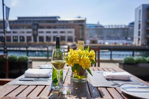 einen Tisch mit einer Flasche Wein und Blumen darauf in der Unterkunft Malmaison Liverpool in Liverpool