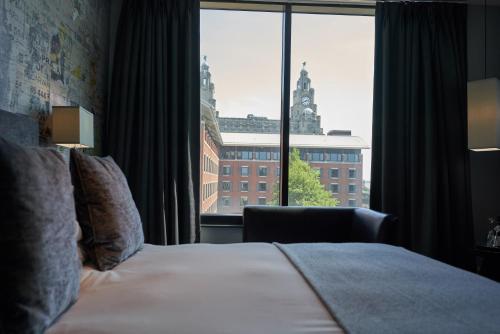 a hotel room with a bed and a large window at Malmaison Liverpool in Liverpool