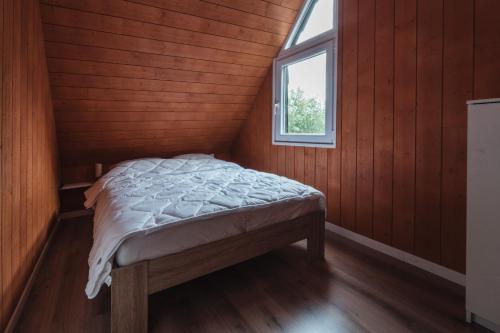 a bedroom with a bed in a room with a window at Terrasses de Malmedy Chalet 113 in Malmedy