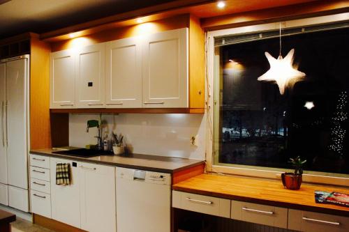 a kitchen with white cabinets and a window with a star on it at GuestHouse Arctic Heart in Rovaniemi