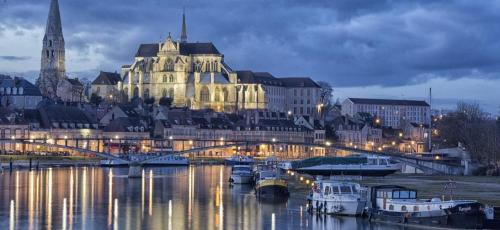 a city at night with boats in the water at Meublé de tourisme La Maison d'Orgy in Chevannes