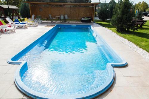 a swimming pool with blue water in a yard at Airport Residence - 5 Mins from Airport in Otopeni