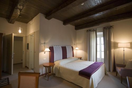 Un dormitorio con una cama grande y una ventana en Hotel Antico Podere Propano, en Saluzzo