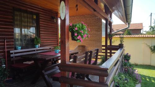a wooden porch with a wooden table and benches at Holiday Home Di More in Jagodina