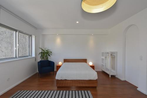 ポルトにあるPorto Republica Flatのベッドルーム1室(ベッド1台、青い椅子付)