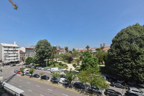 a city street with cars parked in a parking lot at Porto Republica Flat in Porto